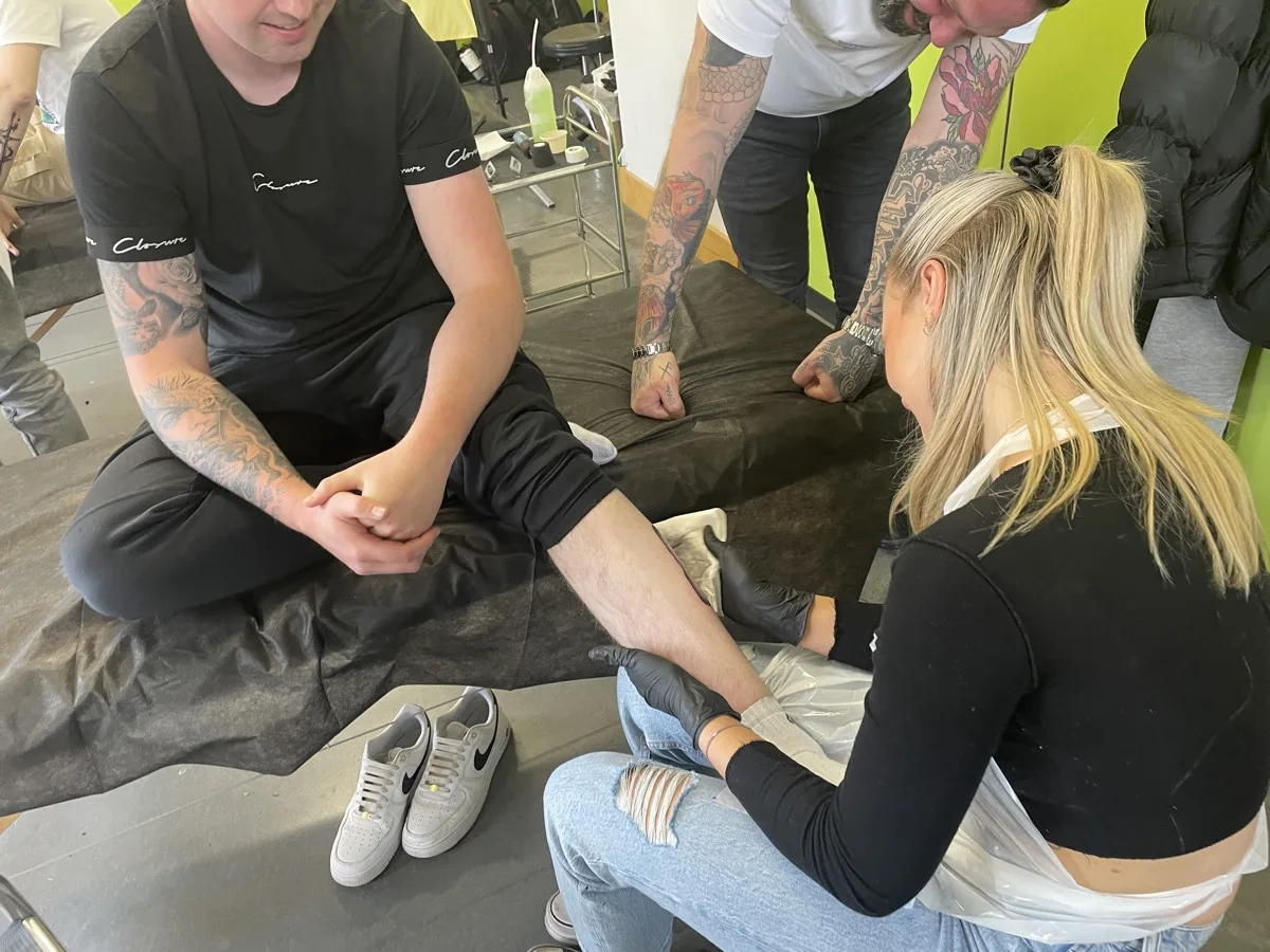 Tattoo students and tutor at work